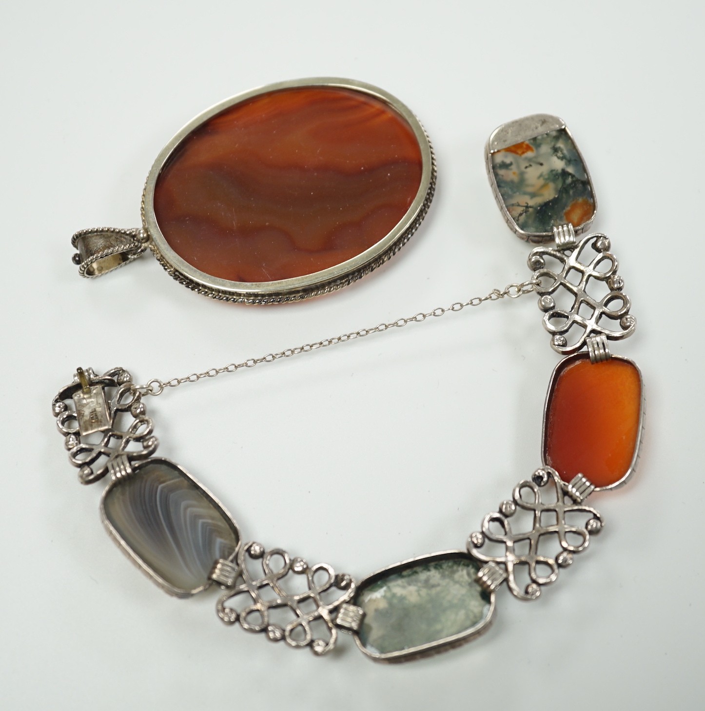 A pierced white metal and four stone agate set bracelet, 18.5cm and a white metal and banded agate set oval pendant.